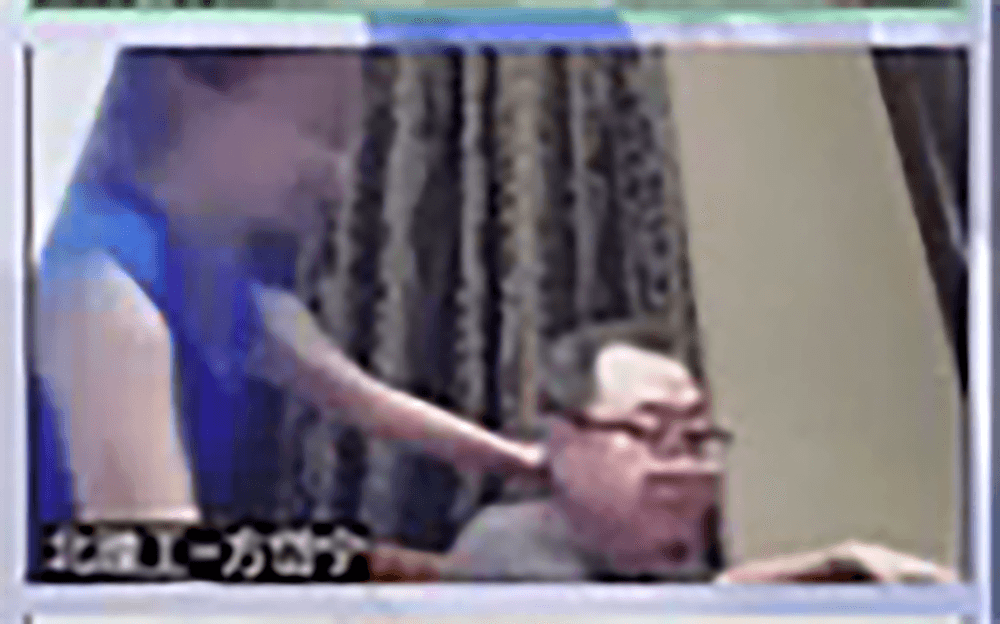 會議期間,一名藍衣女子走到他身旁。翻攝影片截圖