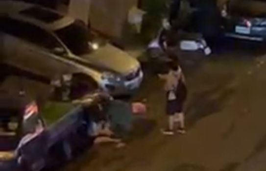 女子坐在地上，旁人欲將她扶起。讀者提供