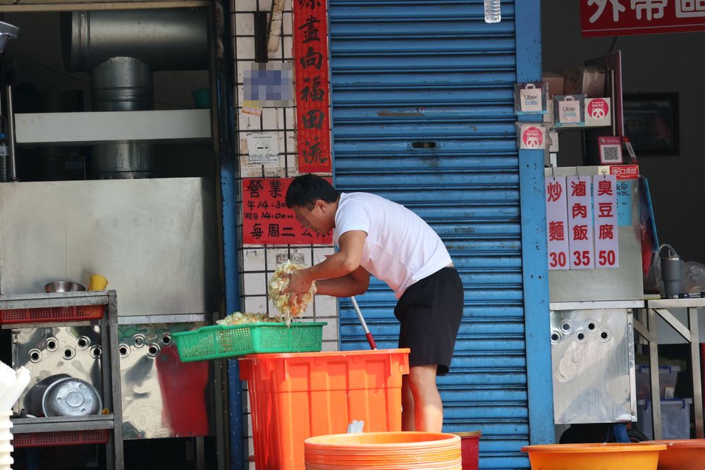 男子在店外雙手抓洗著白菜沒有戴手套和口罩。張喆喜攝