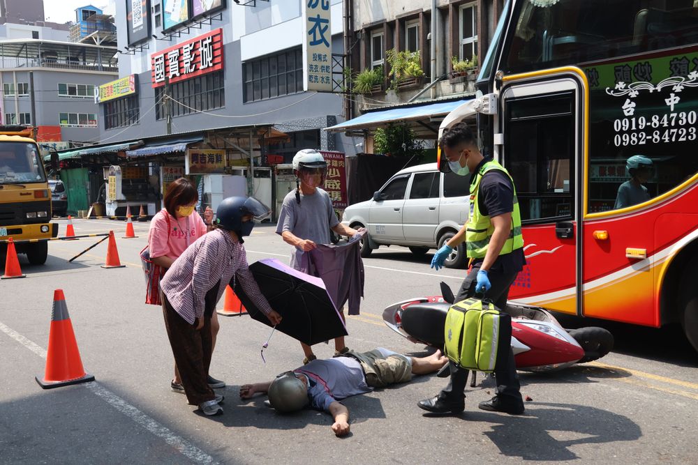 熱心民眾幫忙撐傘遮陽。張喆喜攝