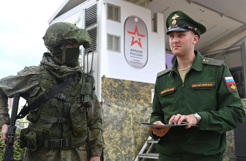 穿戴軍裝、手持槍枝的俄國士兵站在募兵卡車旁，有如活動看板人物。路透社