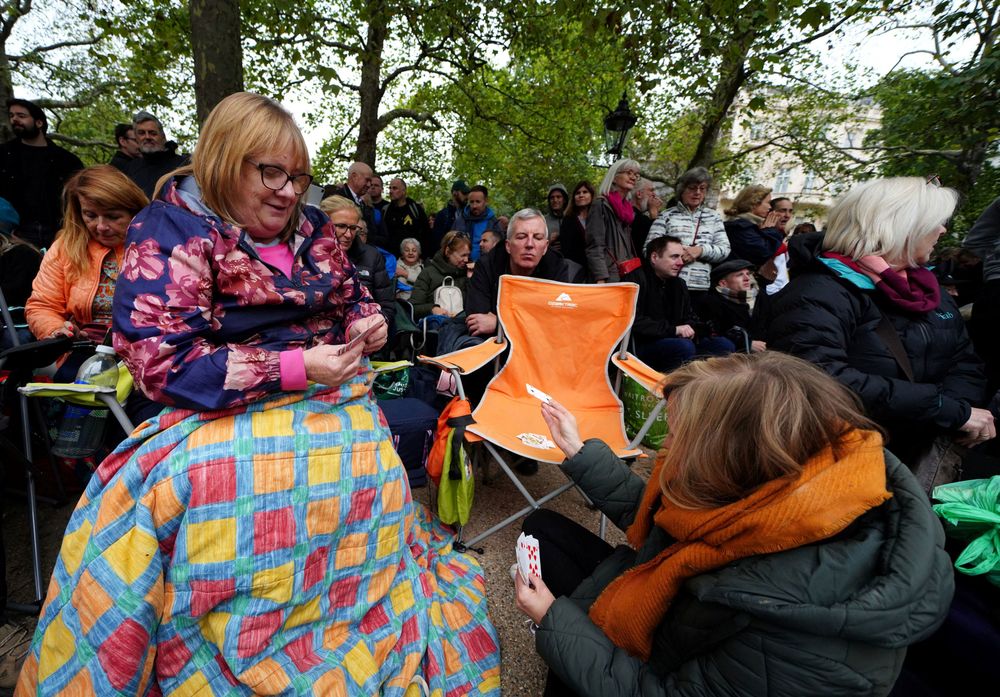 早早到場占位子的民眾，打撲克牌消磨時間。路透社