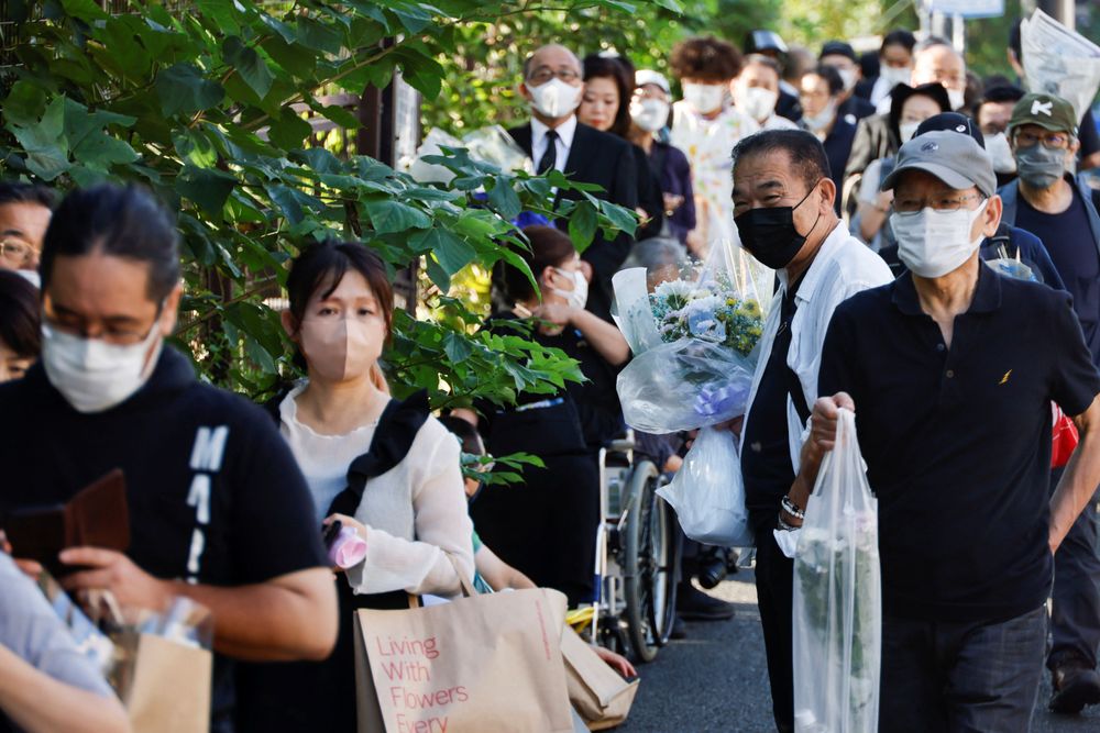 大批民眾等候赴武道館外獻花台獻花。路透社