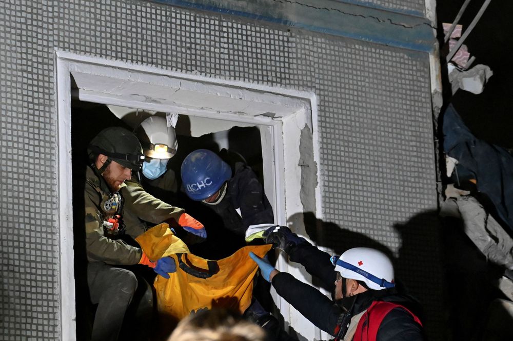 救難人員從一扇破損的窗戶救出受困民眾。路透社