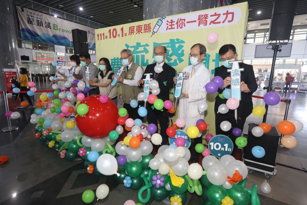 縣府在屏東火車站開流感疫苗記者會，以針戳破象徵疫毒的氣球。羅琦文攝