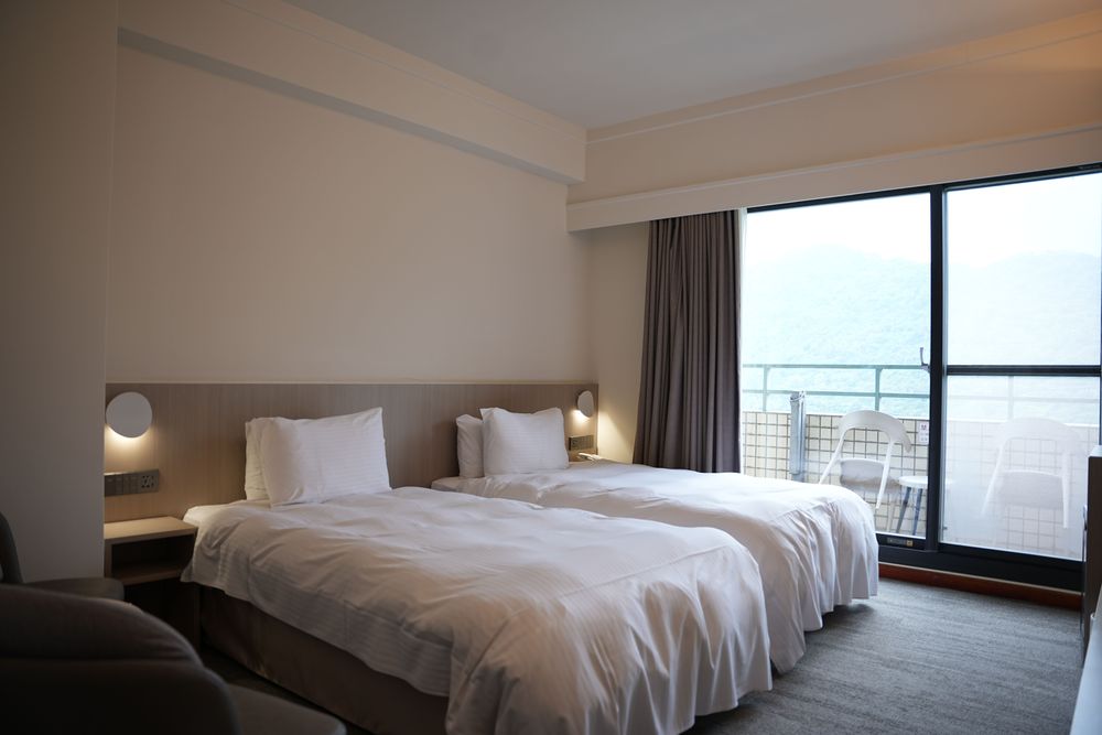 全馆客房皆附有私人阳台，透过开窗即景的设计将视觉延伸至户外景观。黄盈甄摄