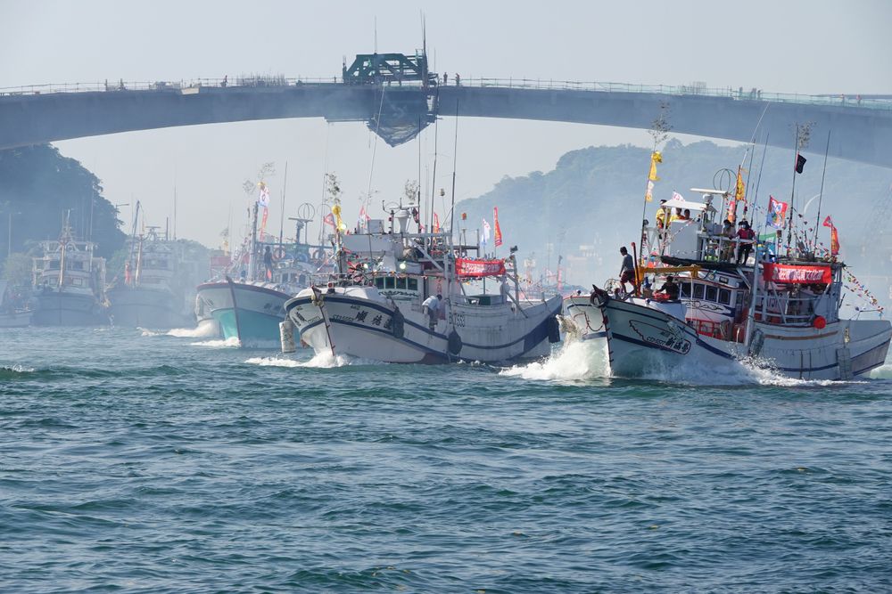 百艘海上遶境船團從漁港魚貫駛出。林泊志攝