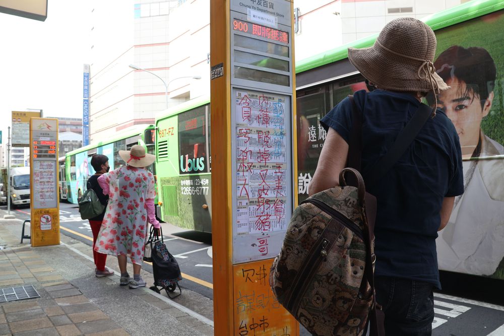 民眾停下腳步看招牌寫了些什麼內容。張喆喜攝