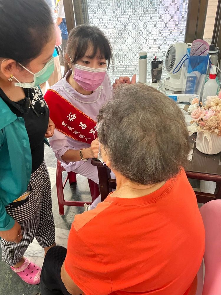 高慧靜身著護理師服為里內老人量血壓、義剪。高慧靜提供
