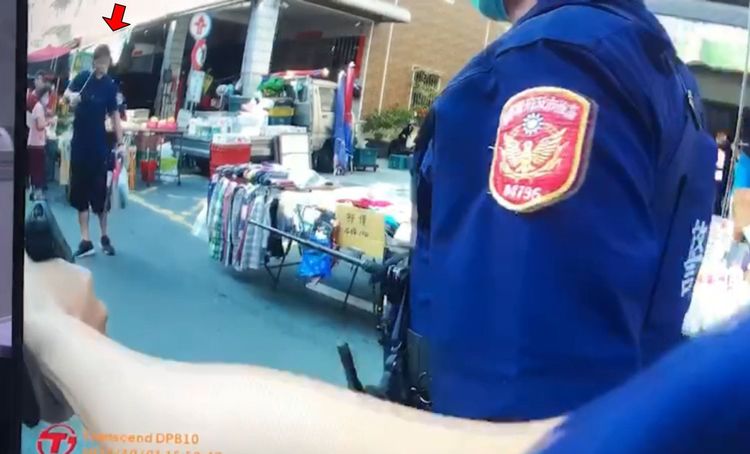 嫌犯蕭姓男子(紅色箭頭處)手持多把刀械，在內惟市場內與持槍的警員對峙。讀者提供