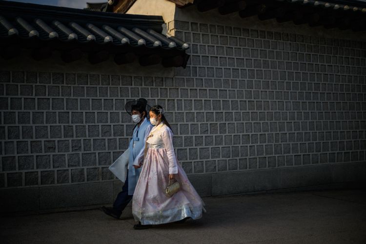 穿著傳統韓服的民眾在南韓首爾的景福宮外散步。法新社