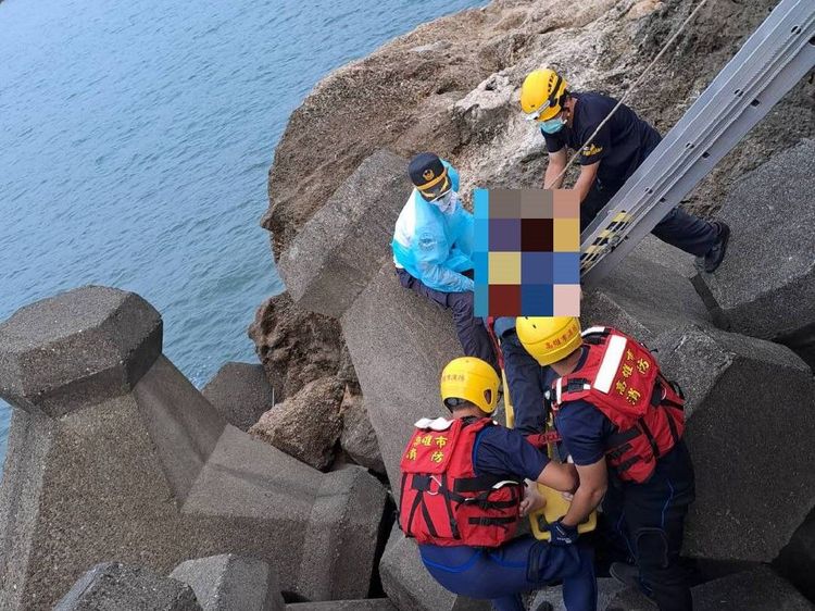 消防人員將鍾姓女子搶救上岸。讀者提供