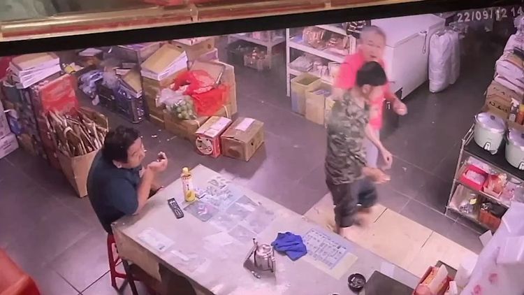 林男跌倒後被店家老闆攙扶至門外。讀者提供