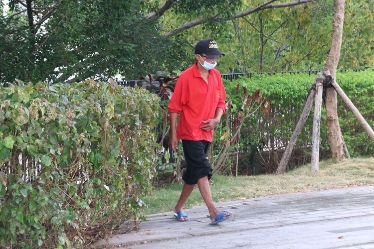 紅衣男子街友直接在花圃便溺。張喆喜攝