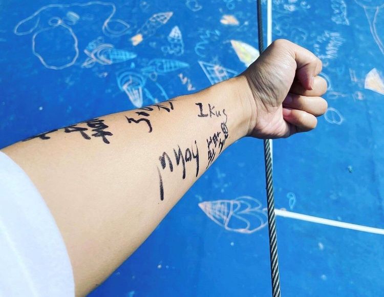 炎亞綸秀出手臂上與孩子們遊玩的印記。至善基金會提供
