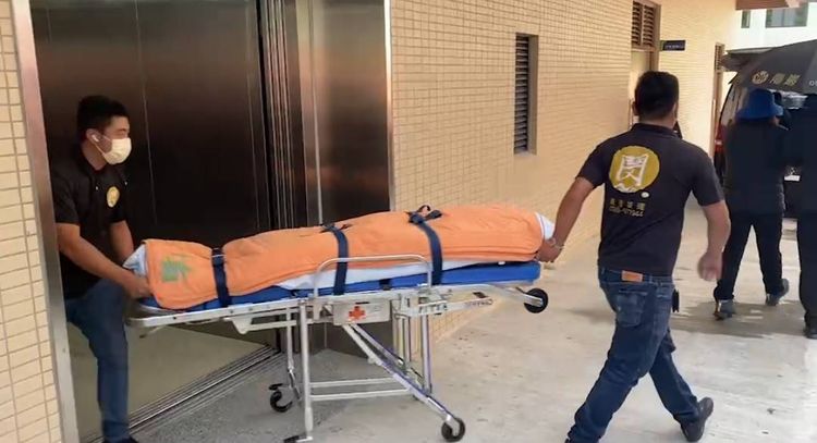 禮儀社人員迅速將遺體推出上車。民眾提供