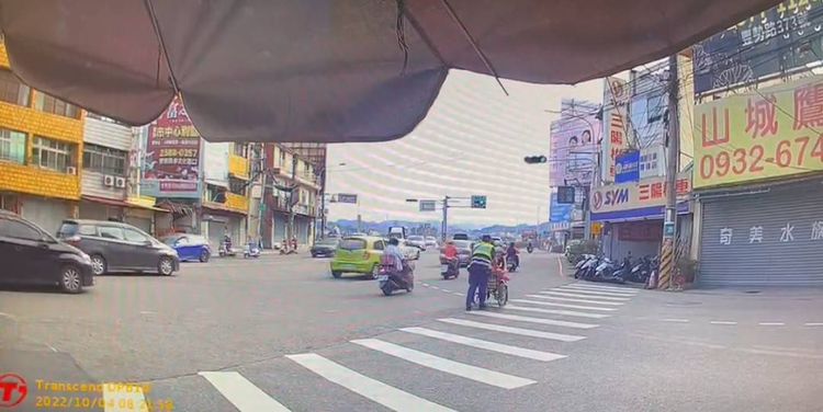 所長推著老婦過馬路後，又協助她送醫。民眾提供