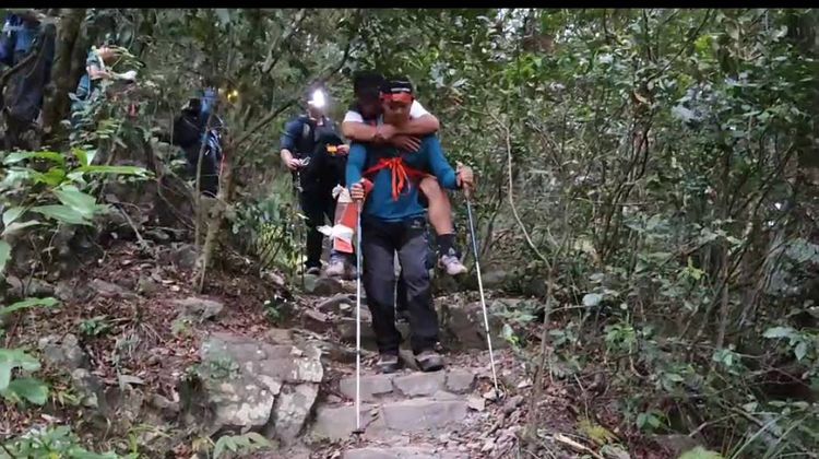 搜救人員輪流用揹負方式將傷者揹下山。民眾提供