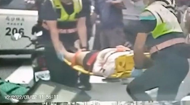 陳女遭斷裂倒塌的交通號誌砸傷，救護人員將其緊急送醫。民眾提供