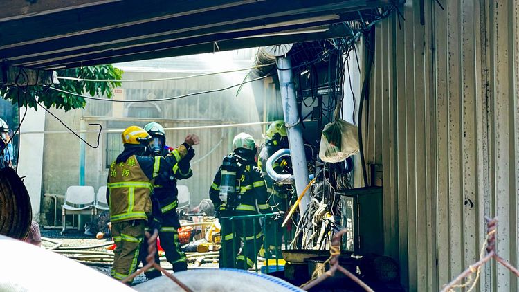 消防員在屋後方討論滅火對策。古和純攝