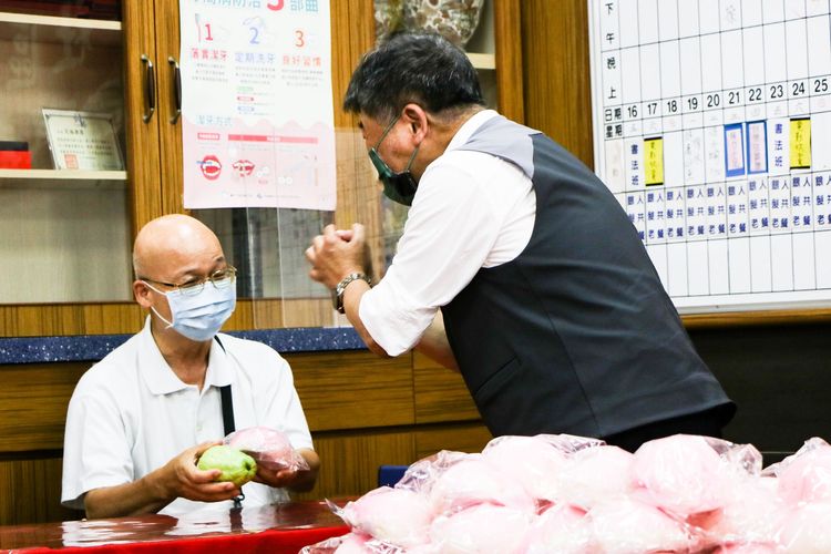 陳時中（右）發芭樂和壽桃給長輩。賴昀岫攝