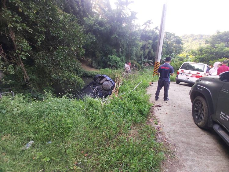 轎車在路口轉彎操控不當，車子倒車時失控墜落池塘。民眾提供