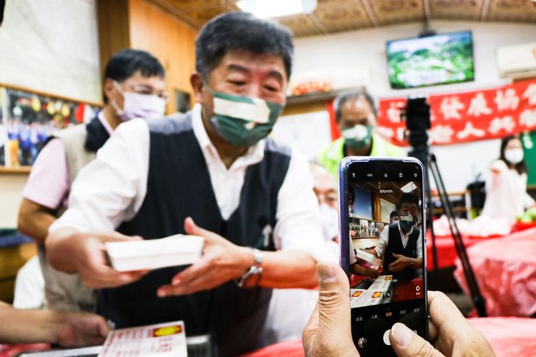 有長輩拿手機拍攝陳時中發便當的畫面。賴昀岫攝