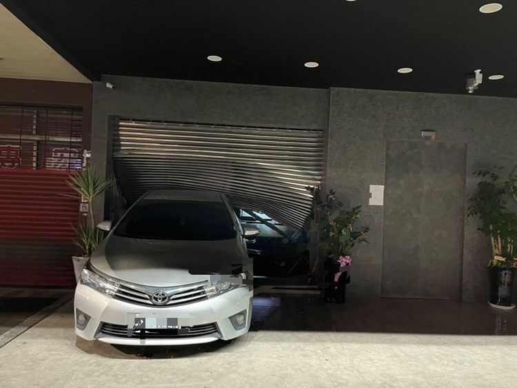 該車倒車衝撞破門後，駕駛立即逃離現場。讀者提供