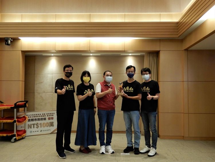 環保局程大維局長(右1)率許銘志簡任技正(右2)與城鄉局黃國峰局長(左1)率陳柏君副總工程司(左2)代表於市政會議，獻獎予市長侯友宜(中)。環保局提供