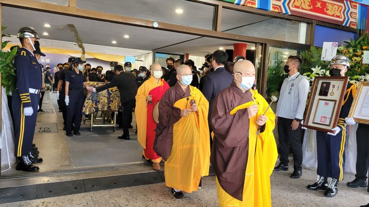 在法師誦經聲中兩名殉職警靈柩上靈車前往火葬場。劉榮輝攝