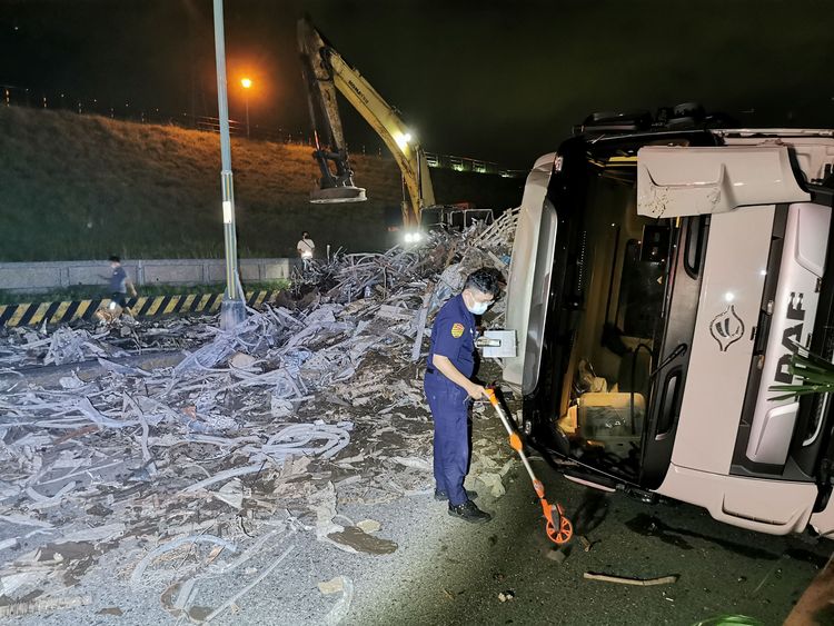 曳引車翻覆廢鐵灑滿整個馬路，警方到場採證。陸運鋒攝