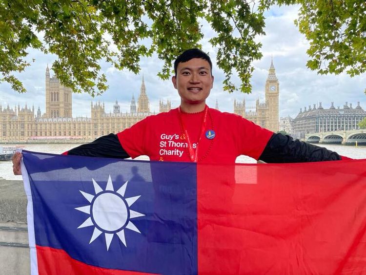 王建智在挑戰時展示國旗。中央社