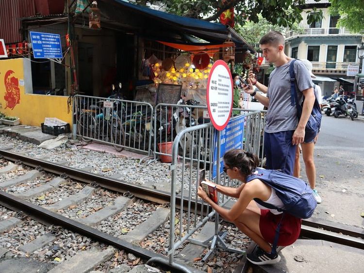 慕名到訪河內火車街的國際旅客，只能在鐵柵欄外拍照。中央社