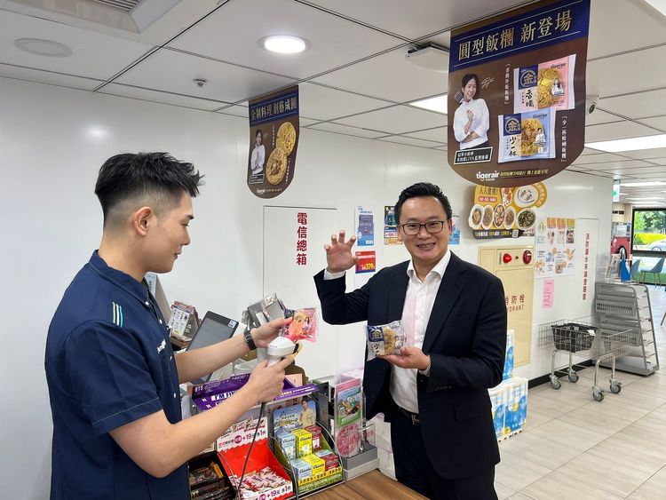台灣虎航董事長陳漢銘（右）親自到全家便利超商選購新上市的全家金飯糰。台虎提供