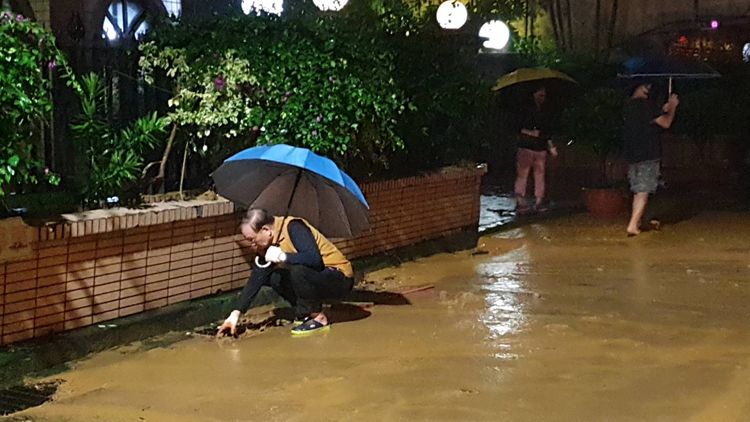 民眾疏通水溝，讓泥水順利流出。戴之聖攝