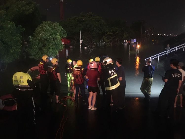 警消人員在岸邊打燈搜尋受困水中民眾。民眾提供