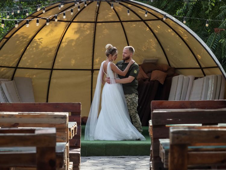 烏克蘭士兵與身穿白紗的新婚妻子在聶伯城一處公園的空蕩舞台上翩然起舞。路透社