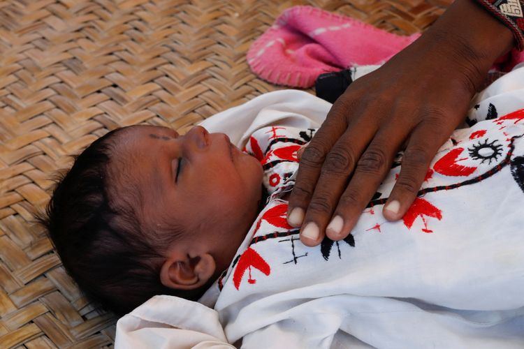 巴基斯坦信德省塞萬市難民營裡，一名出生14天的寶寶由母親哄睡。路透社