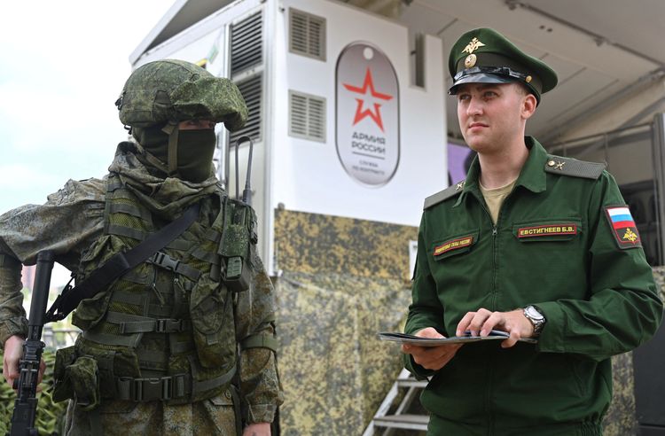 穿戴軍裝、手持槍枝的俄國士兵站在募兵卡車旁，有如活動看板人物。路透社