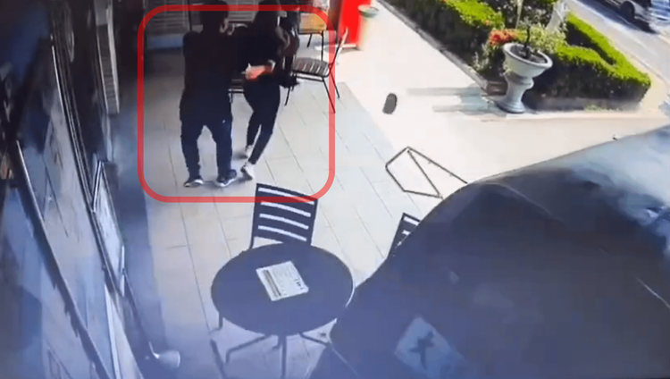 一對男女坐在服務中心前，在靈車直衝而來前慌張逃開。民眾提供