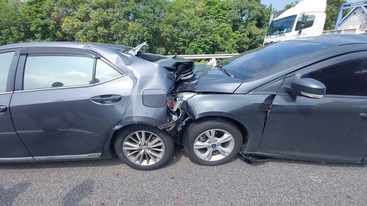 兩部轎車遭夾在中間，車體嚴重毀損。楊永盛攝