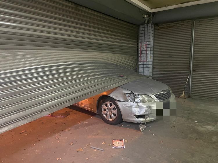 路邊轎車慘遭追撞擠進鐵門內。草爺提供