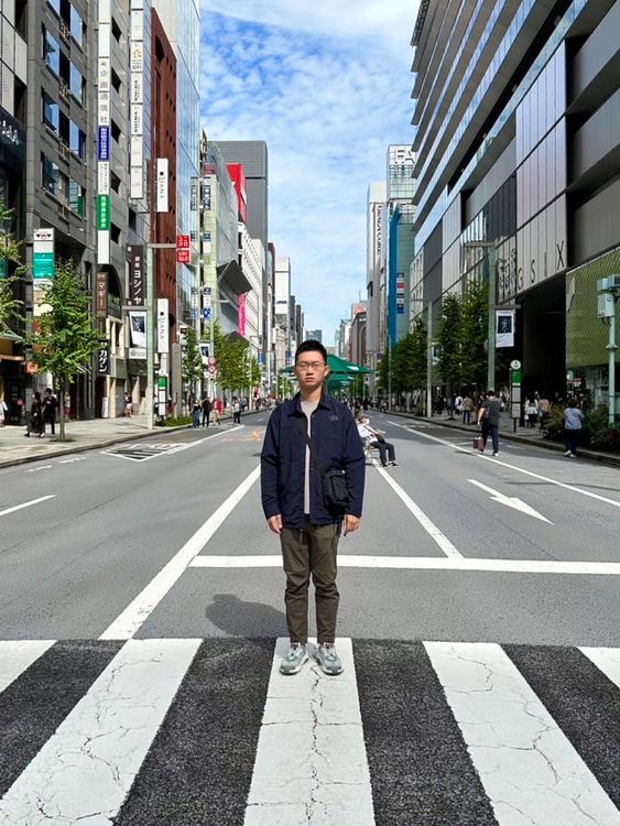 陳子見在東京銀座的「步行者天國（行人徒步區）」，依舊刻意擺出撲克臉。翻攝自臉書「視網膜 Retina」