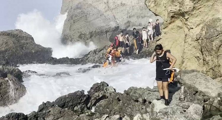 民眾從礁石區返回時遇上大浪。第一三岸巡隊提供