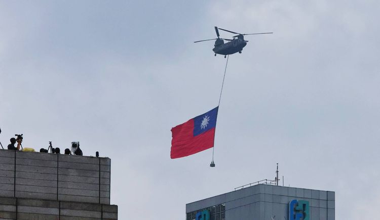 CH-47SD直升機吊掛巨幅中華民國國旗飛越總統府。林林攝