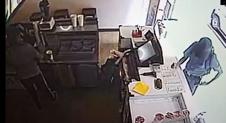 男子將偷來的手機放到自己褲子口袋裡。翻攝畫面