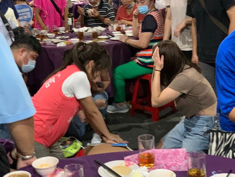 洪佳君（左粉色背心者）立刻以CPR搶救，助病患恢復心跳，隨後交由救護車送醫。鍾小平提供