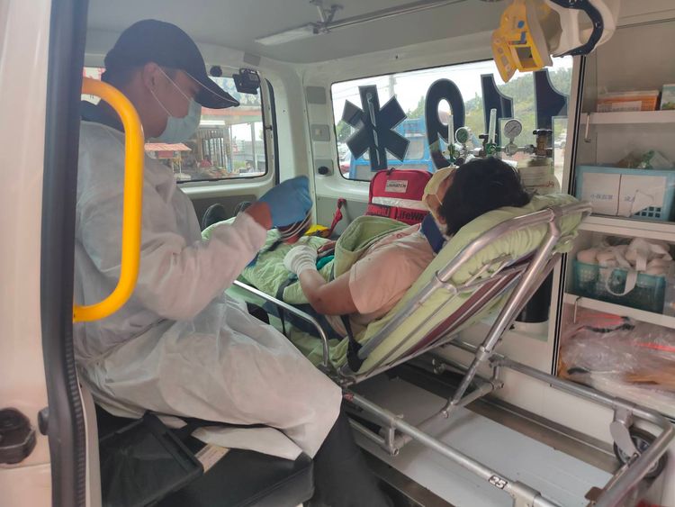 救護人員以人力接駁，終將賴姓婦人抬下山上救護車送醫。民眾提供