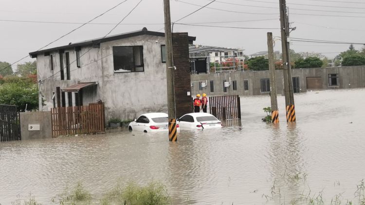 宜蘭溪水暴漲，兩部汽車甚至半個車身就泡在淹水裡。林泊志攝