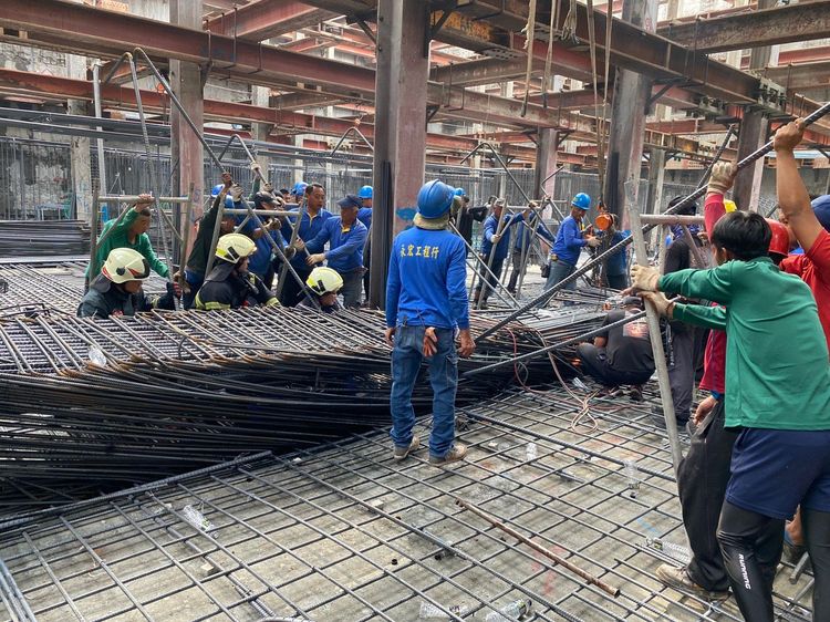 工人被壓在倒塌鋼筋底下。讀者提供